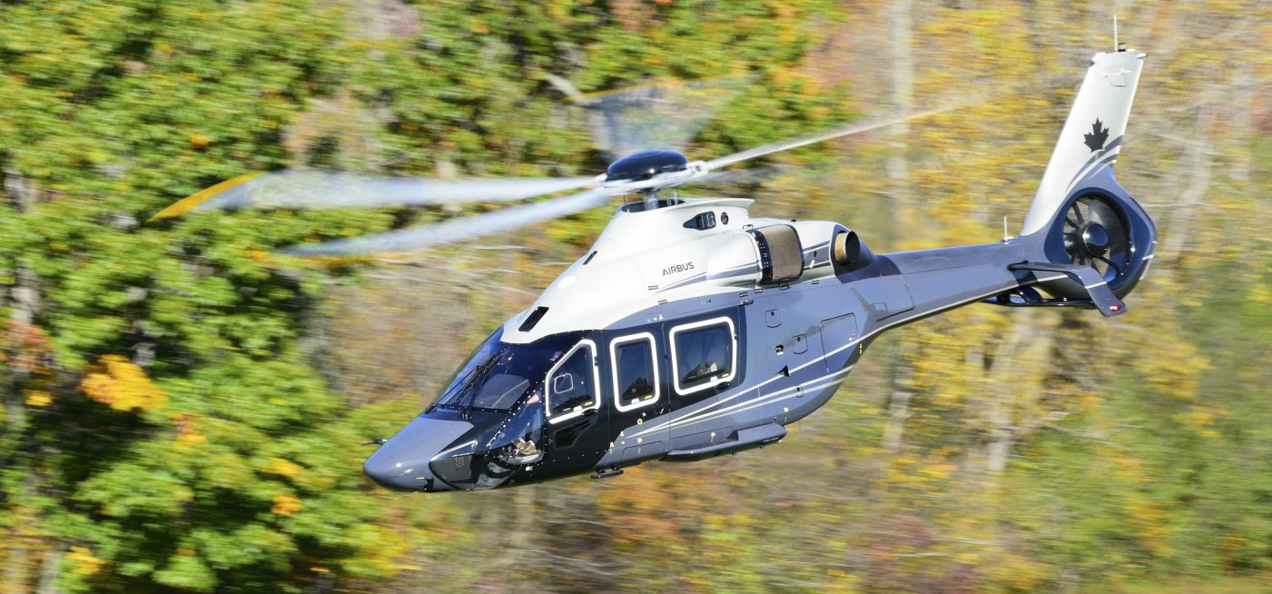 Canadian H160 flying with fall trees in background