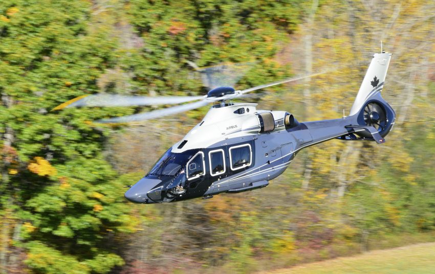 Canadian H160 flying with fall trees in background