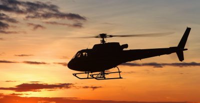 helicopter flying at sunset